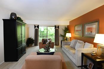 a living room filled with furniture and a large window at Liberty Gardens Apartments, Maryland